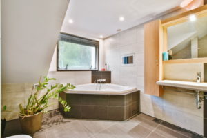 Cozy bathroom with a large bathtub and dark tiled floor